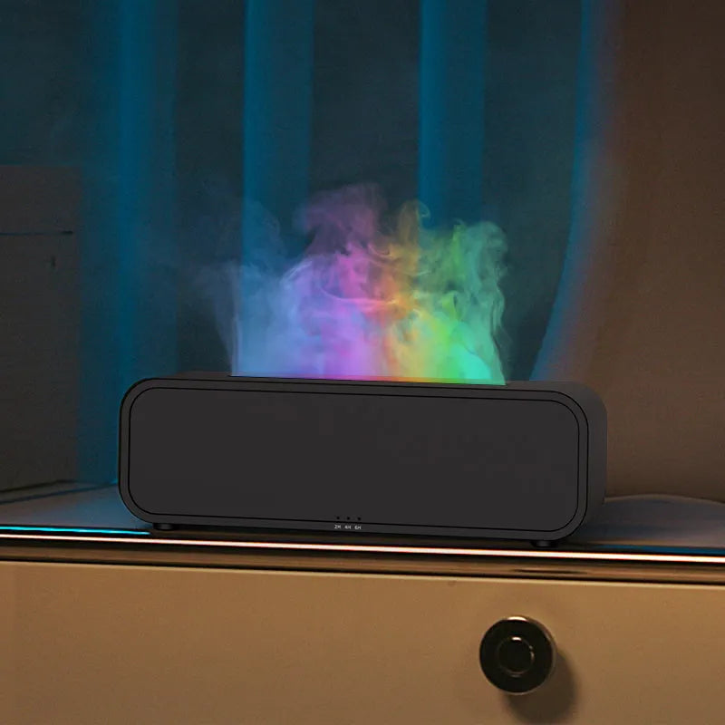 Black USB aroma diffuser with colour-changing LED lights and remote control on a wooden table.
