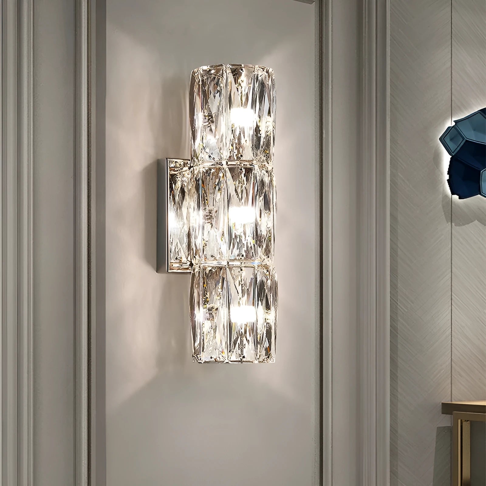 Crystal shade stainless steel wall lamp in chrome finish mounted on a wall.