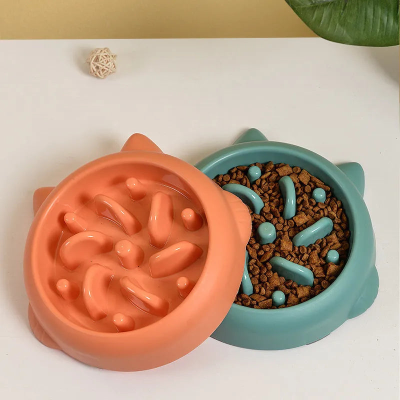Green plastic slow feeder dog bowl with raised bone-shaped ridges inside.