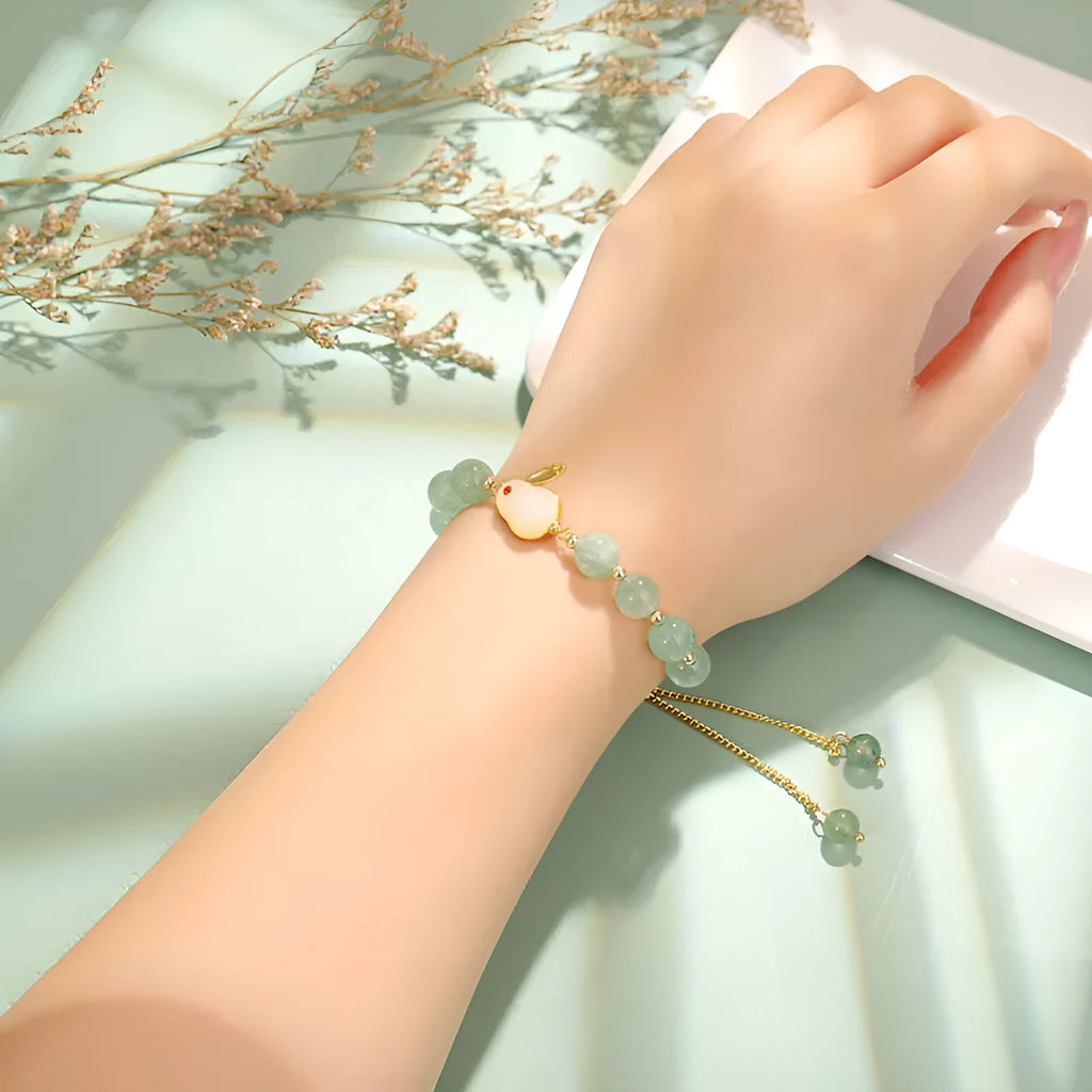 Rabbit charm bracelet with green aventurine stone on copper and gold chain.