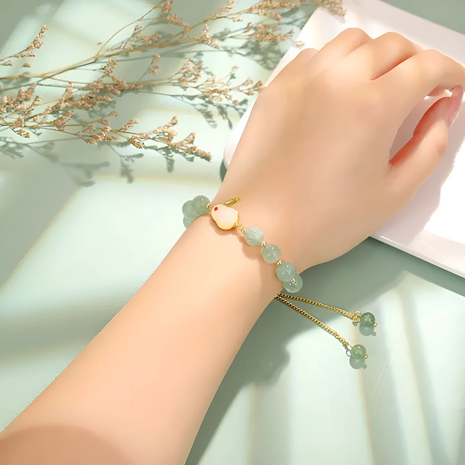 Rabbit charm bracelet with green aventurine stone on copper and gold chain.