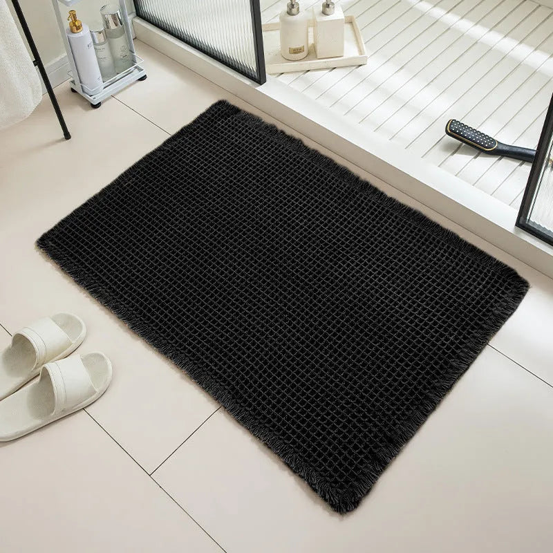 Square checkered pattern bathroom carpet on tiled floor in light grey colour.