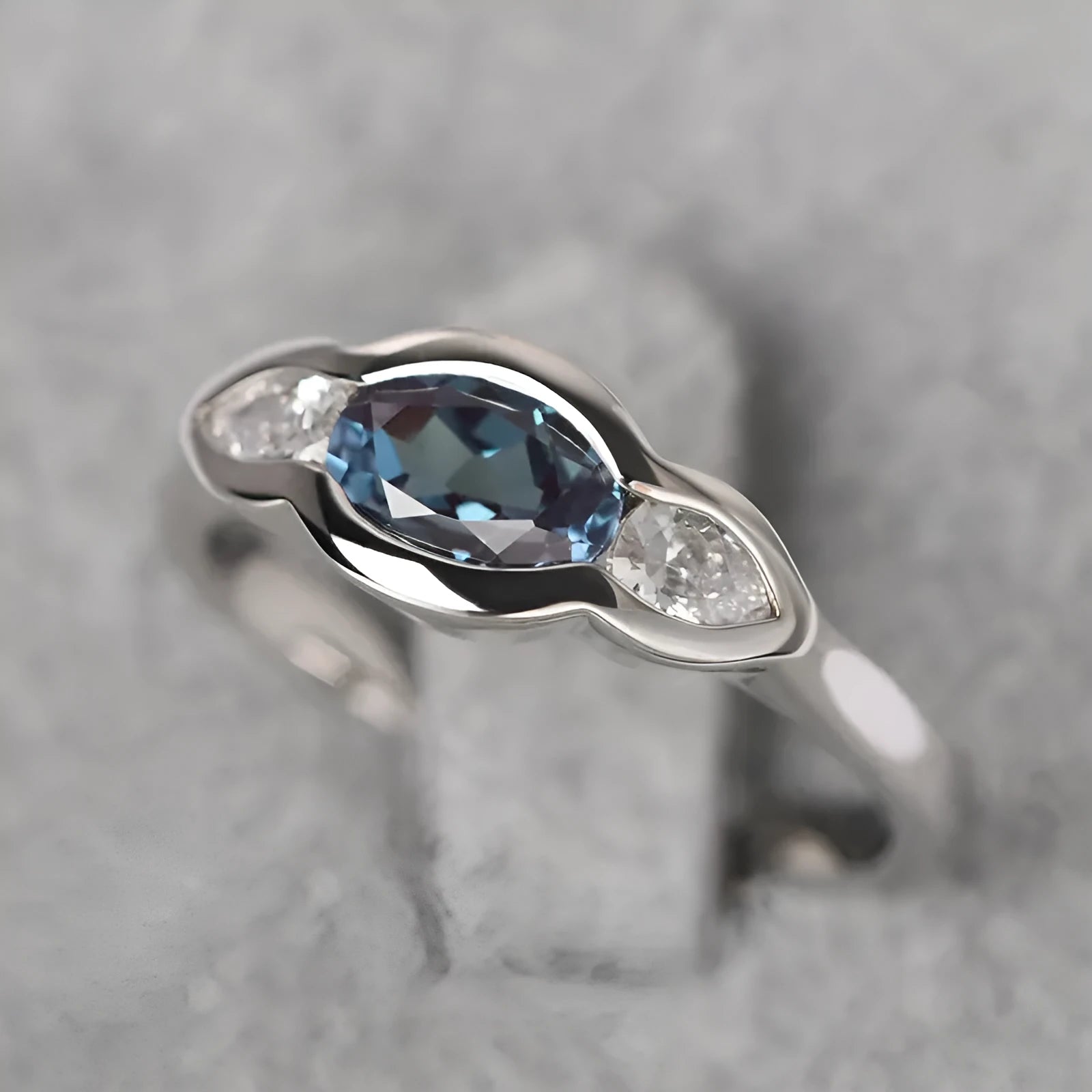 Geometric ellipse-shaped women's ring in white gold colour with inlaid zircon stones.