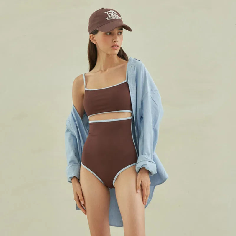 Brown triangle-style one-piece swimsuit for women on a hanger.