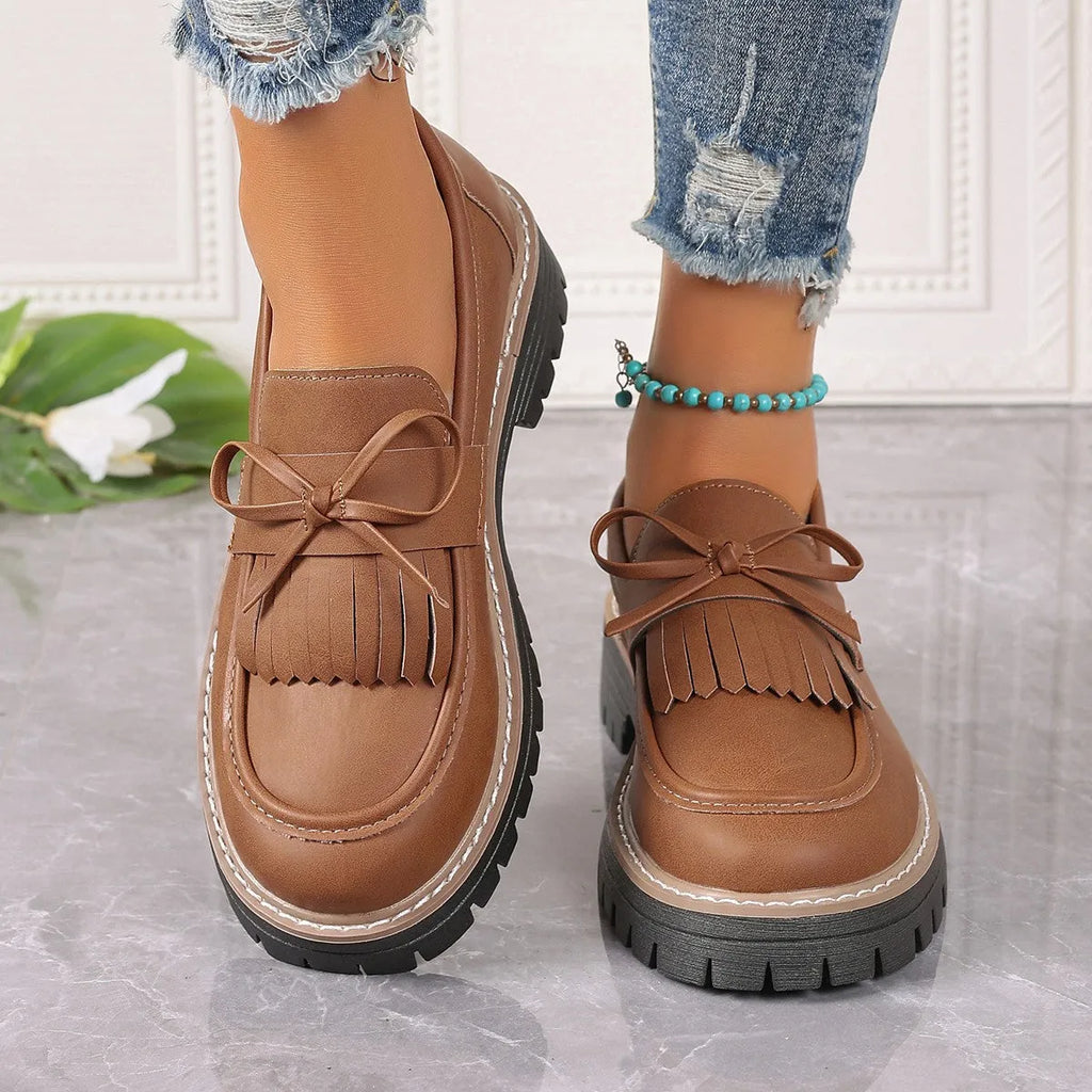 Brown plus size women's loafers with a tassel and bowknot detail on a chunky thick heel.