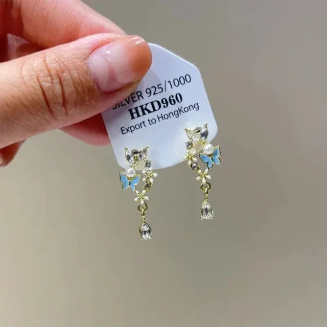 Silver-colour geometric heart-shaped clip-on earrings with rhinestones and dangling star tassels.