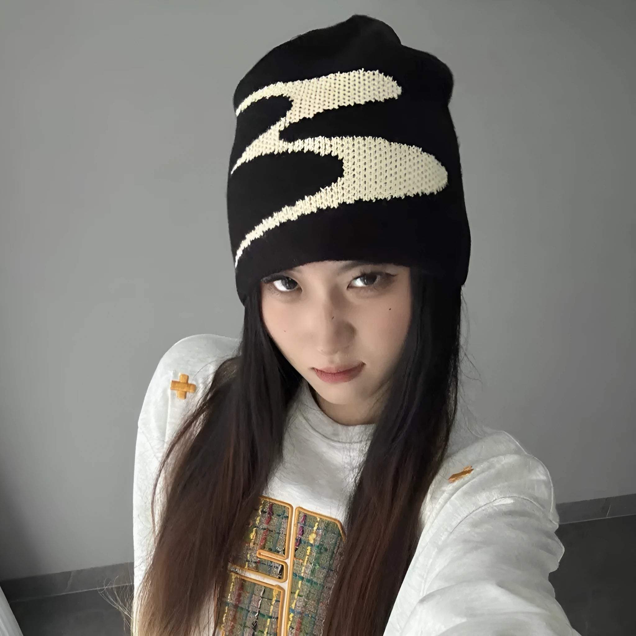 Unisex acrylic knitted beanie hat in black, shown flat.