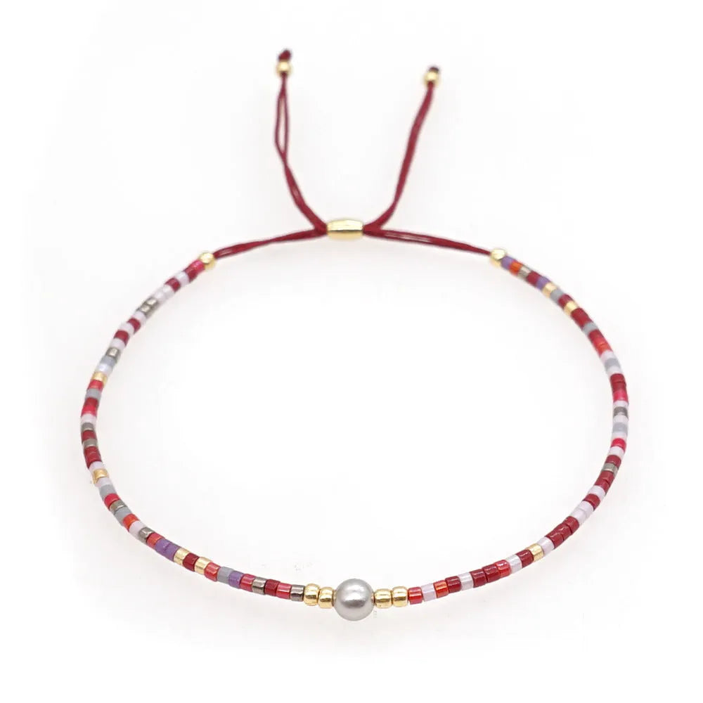 Handmade Bohemian-style women's bracelet with colourful geometric glass beads and lucky stone charms.