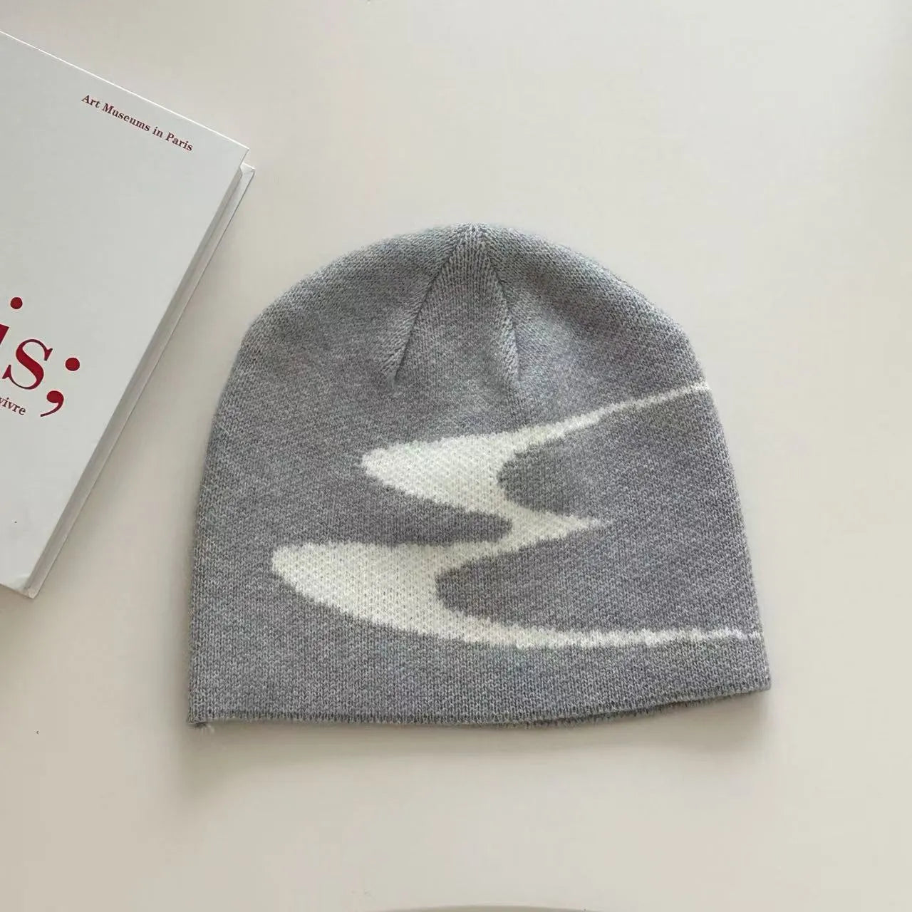 Unisex acrylic knitted beanie hat in black, shown flat.