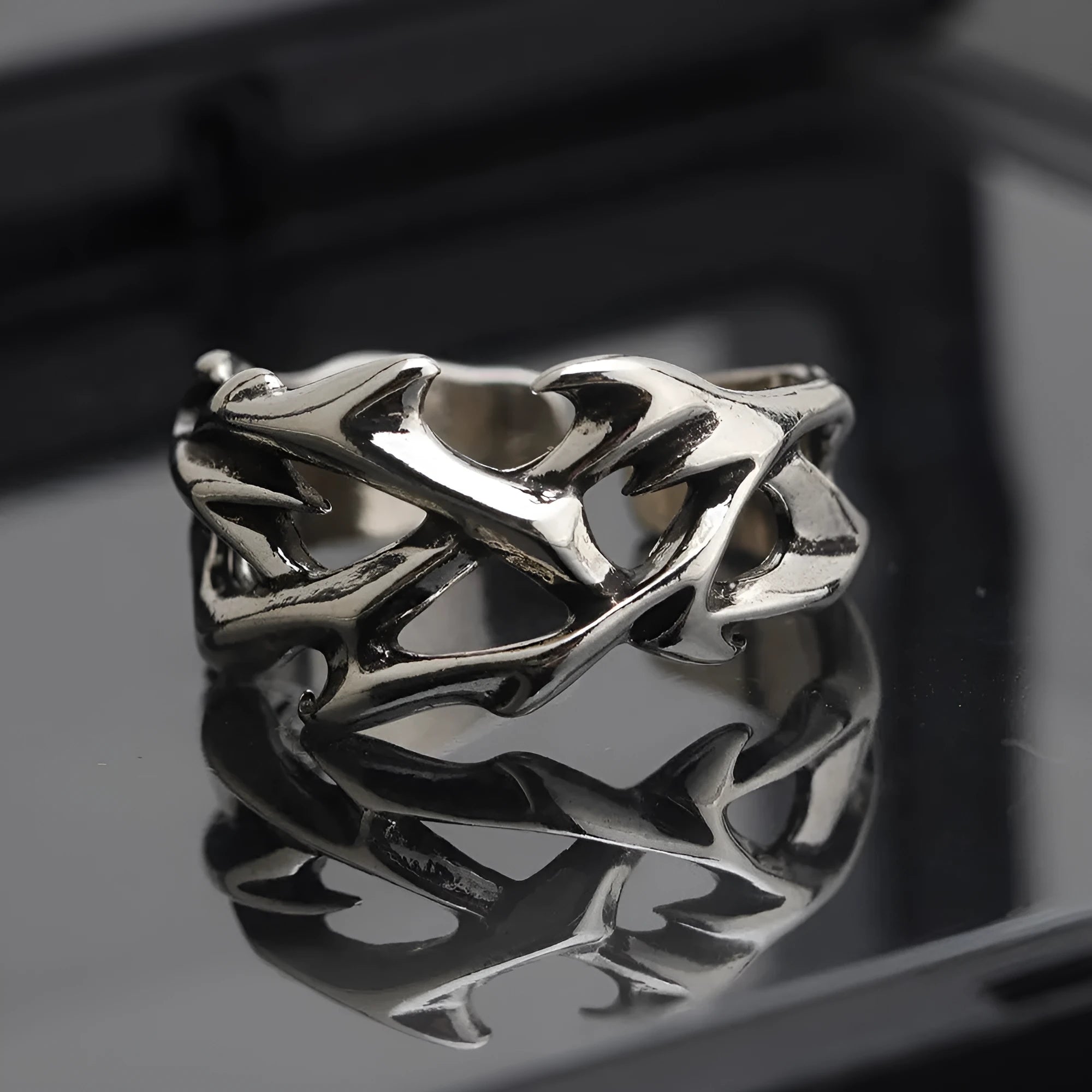 Copper geometric thorn flower ring with adjustable band on a grey background.