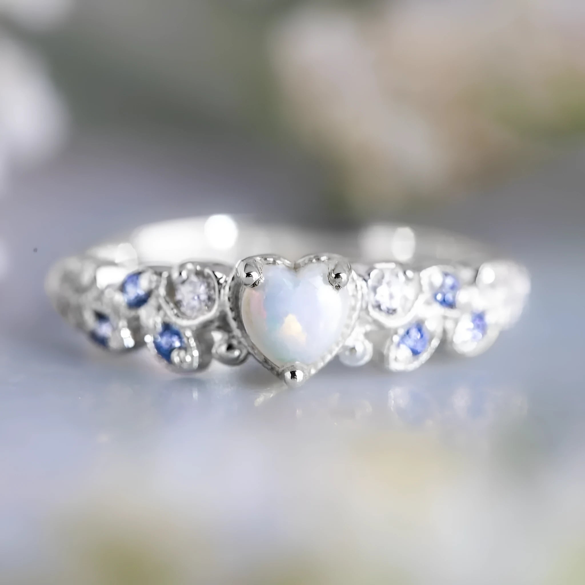 Silver women's ring featuring a heart shape with a floral opal stone in the centre.