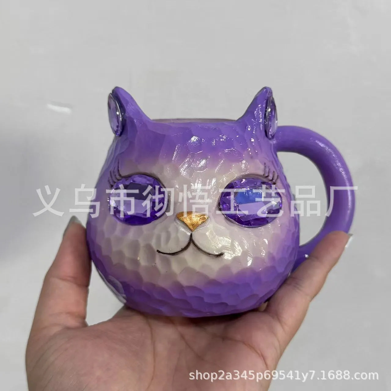 Purple, green, blue, and pink resin cat cup crystal earth craft ornament on display.