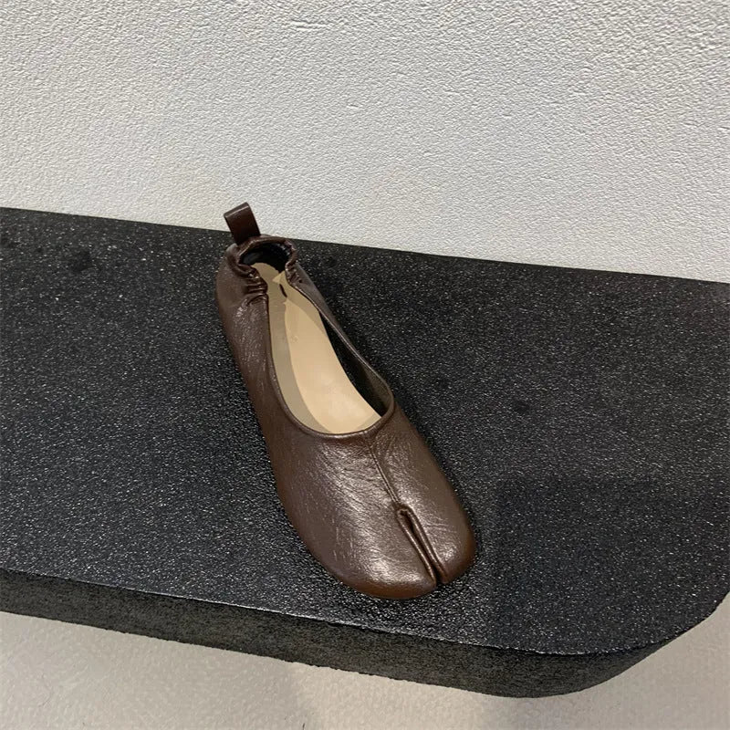 Women's black chunky heel pumps with a horseshoe split toe and round toe design.