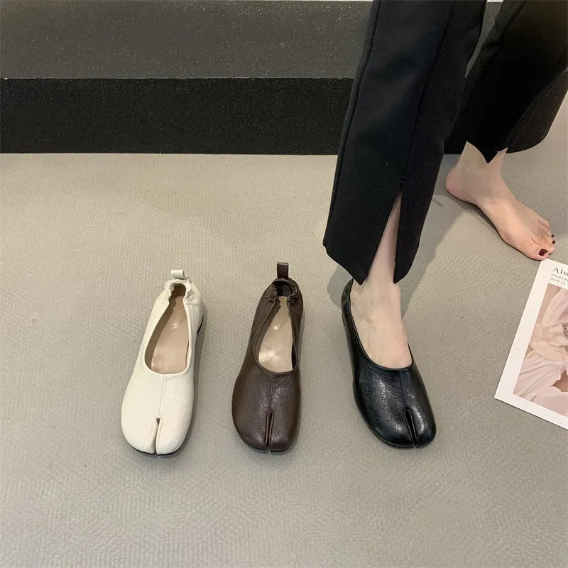 Women's black chunky heel pumps with a horseshoe split toe and round toe design.