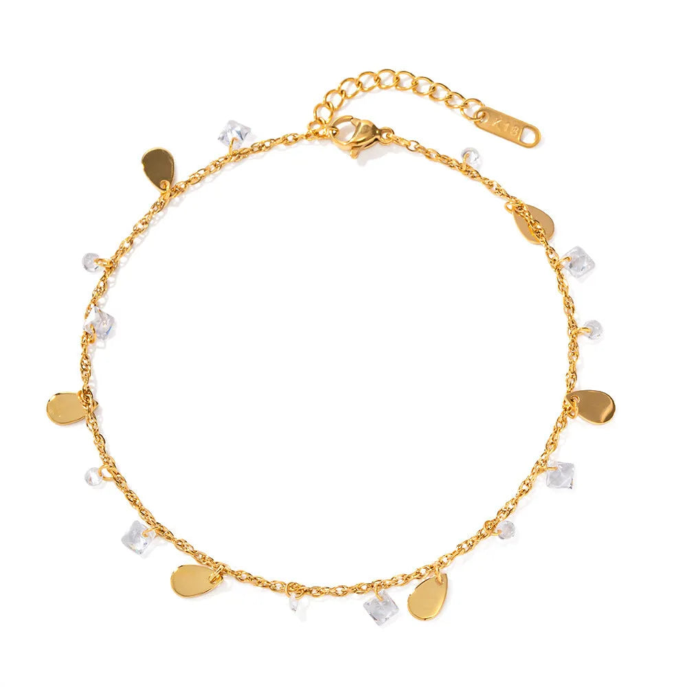 Close-up of a women's stainless steel anklet with a geometric water drop tassel charm on an adjustable chain.