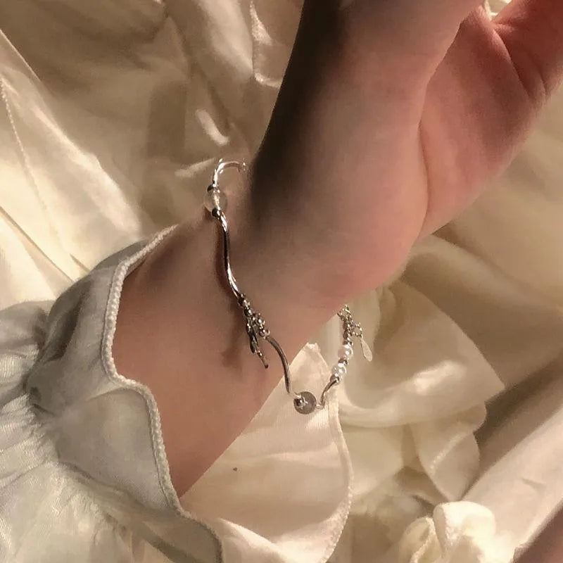 Pearl fishtail bracelet with irregular asymmetric bow in alloy