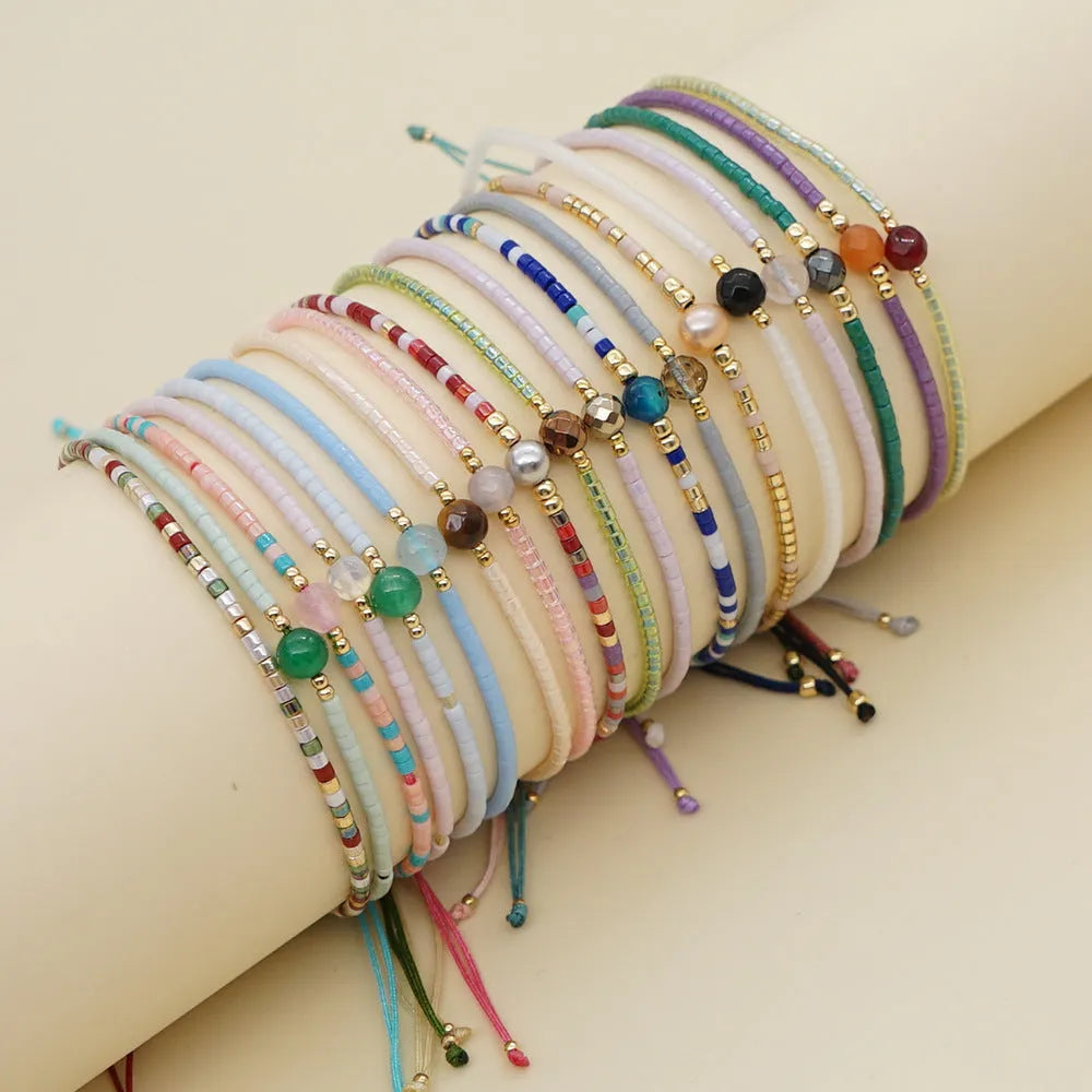 Handmade Bohemian-style women's bracelet with colourful geometric glass beads and lucky stone charms.