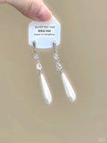Silver-colour geometric heart-shaped clip-on earrings with rhinestones and dangling star tassels.