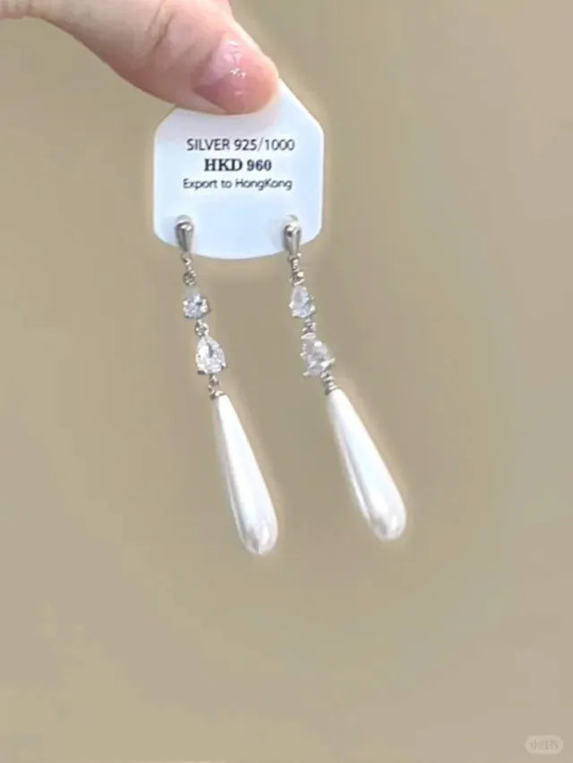 Silver-colour geometric heart-shaped clip-on earrings with rhinestones and dangling star tassels.