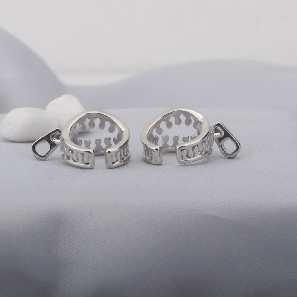 A pair of geometric copper clip-on earrings with a bone clip fastening and linear detail.