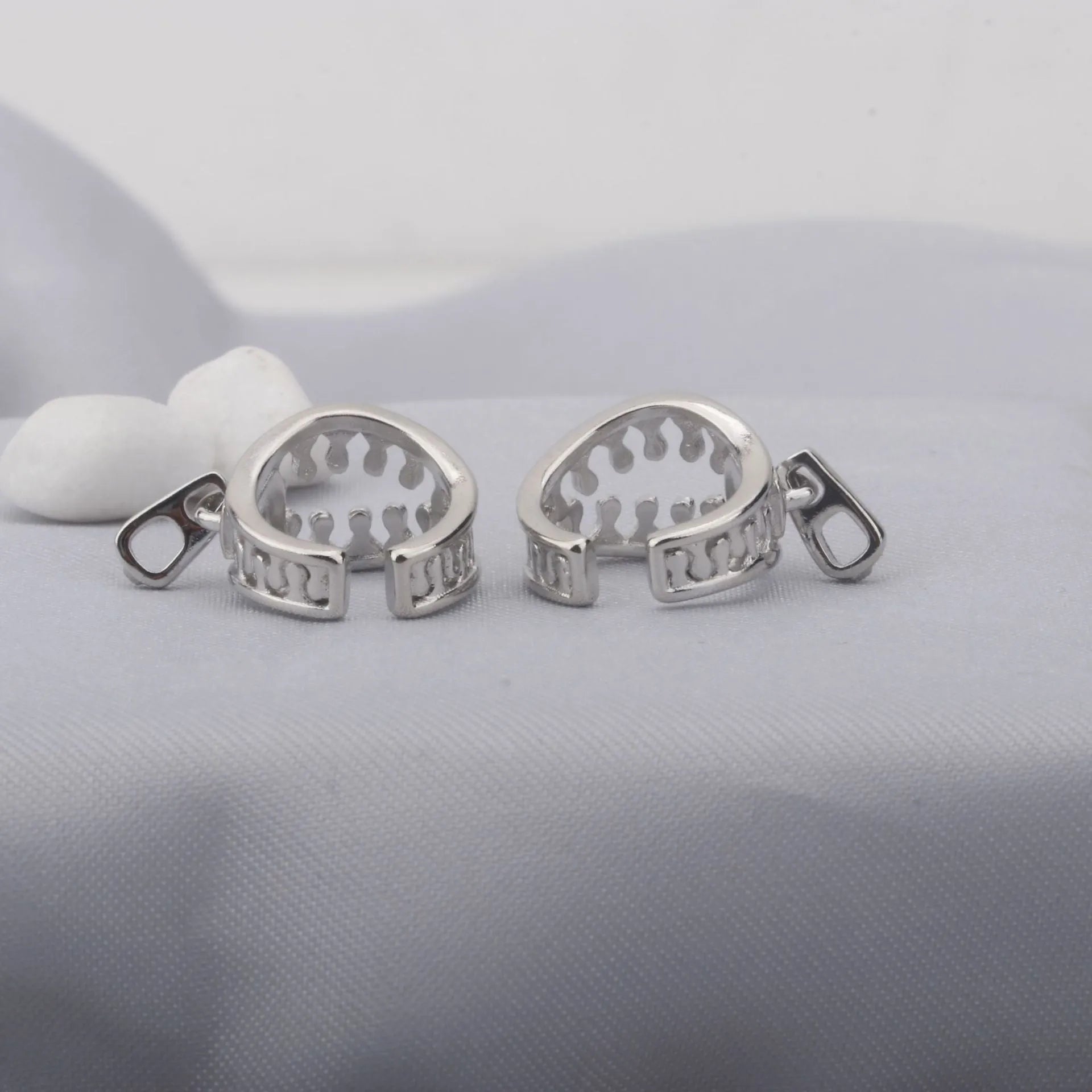 A pair of geometric copper clip-on earrings with a bone clip fastening and linear detail.