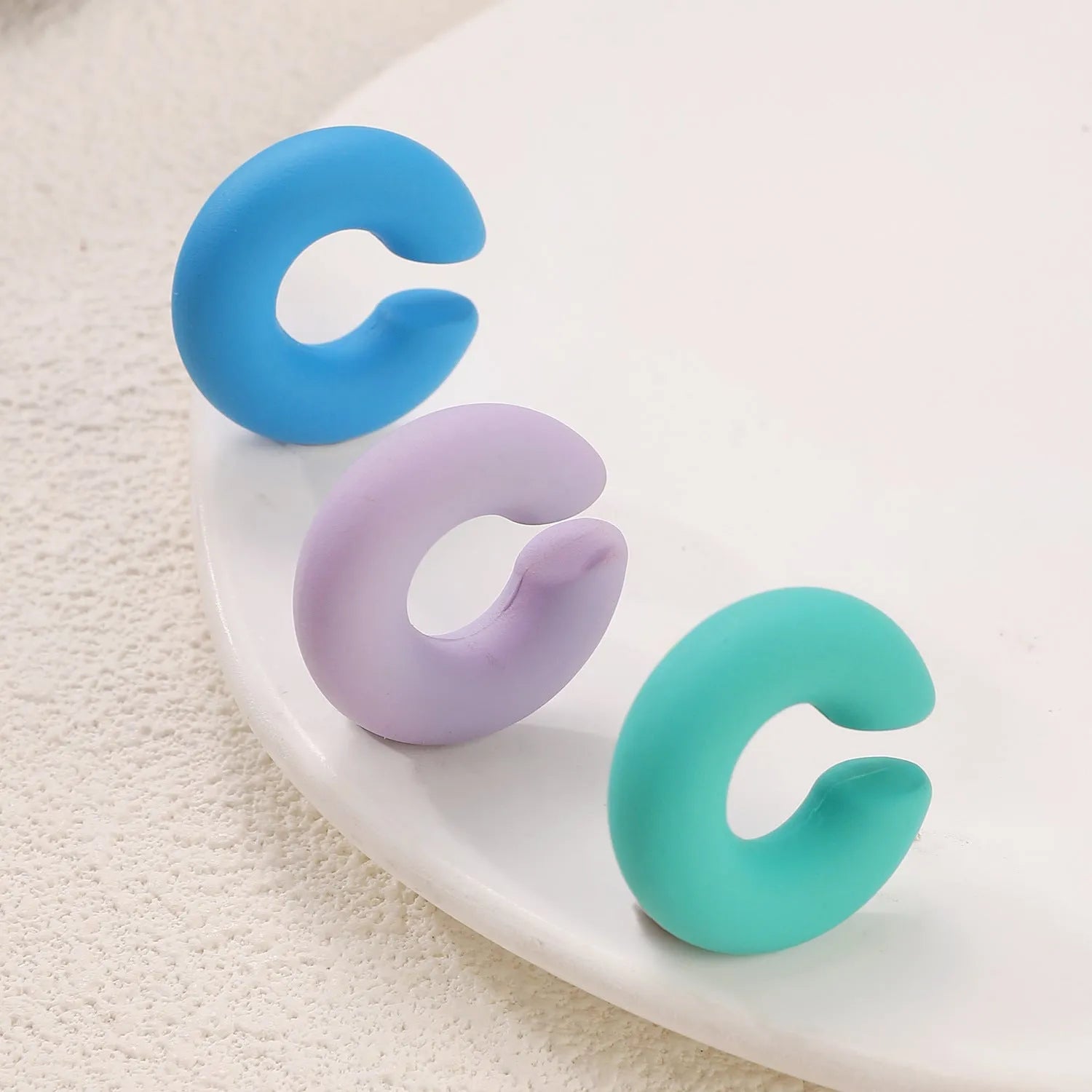 Matte finish C-shaped geometric clip-on earrings in assorted candy colours