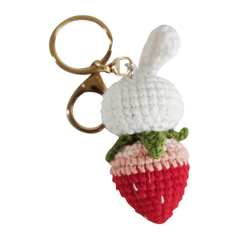 White hand-woven wire rabbit pendant with strawberry pattern attached to a key ring
