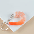 Realistic PVC shrimp-shaped keychain with door buckle attachment on white background.
