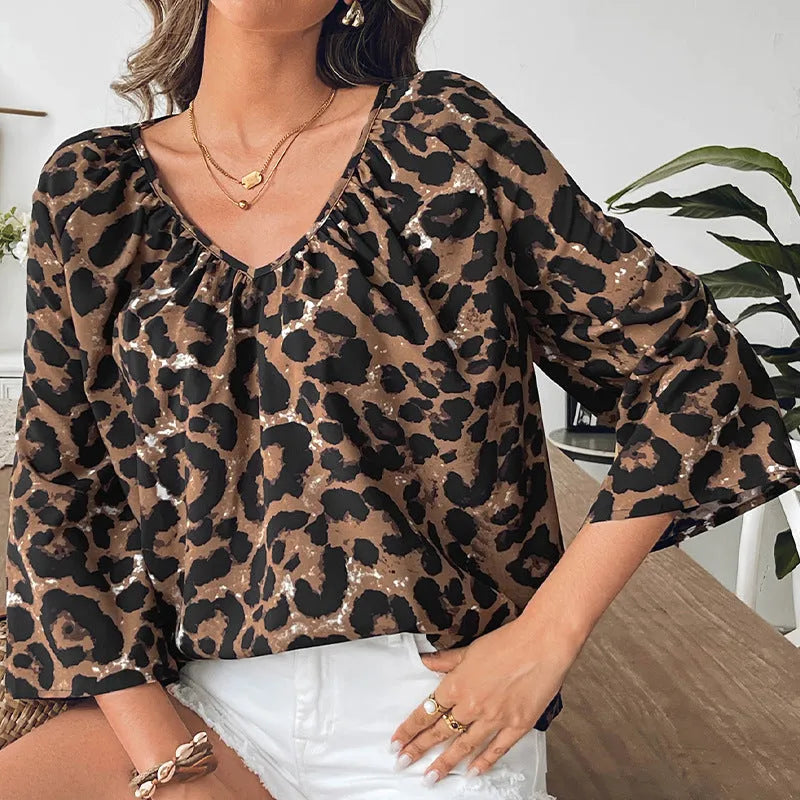 Women's multicolour leopard print V-neck pullover top with half sleeves on a hanger.