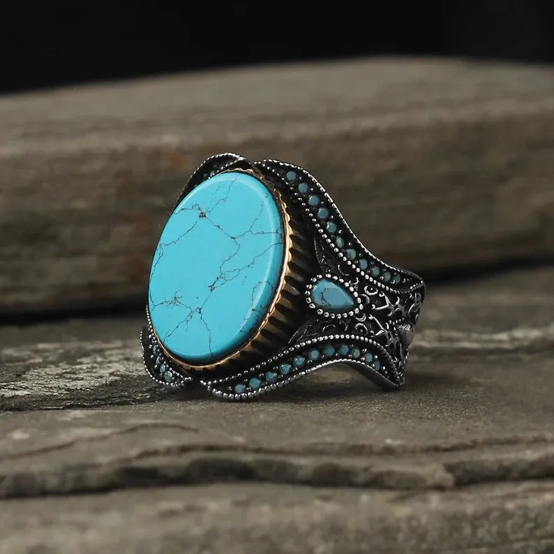 Men's antique silver alloy ring with round band and central turquoise stone on finger