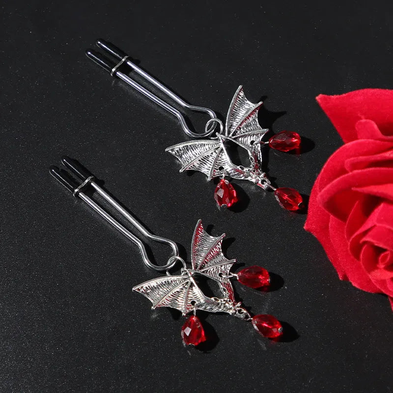 Silver bat-shaped nipple clamp with ruby detail and adjustable tension mechanism