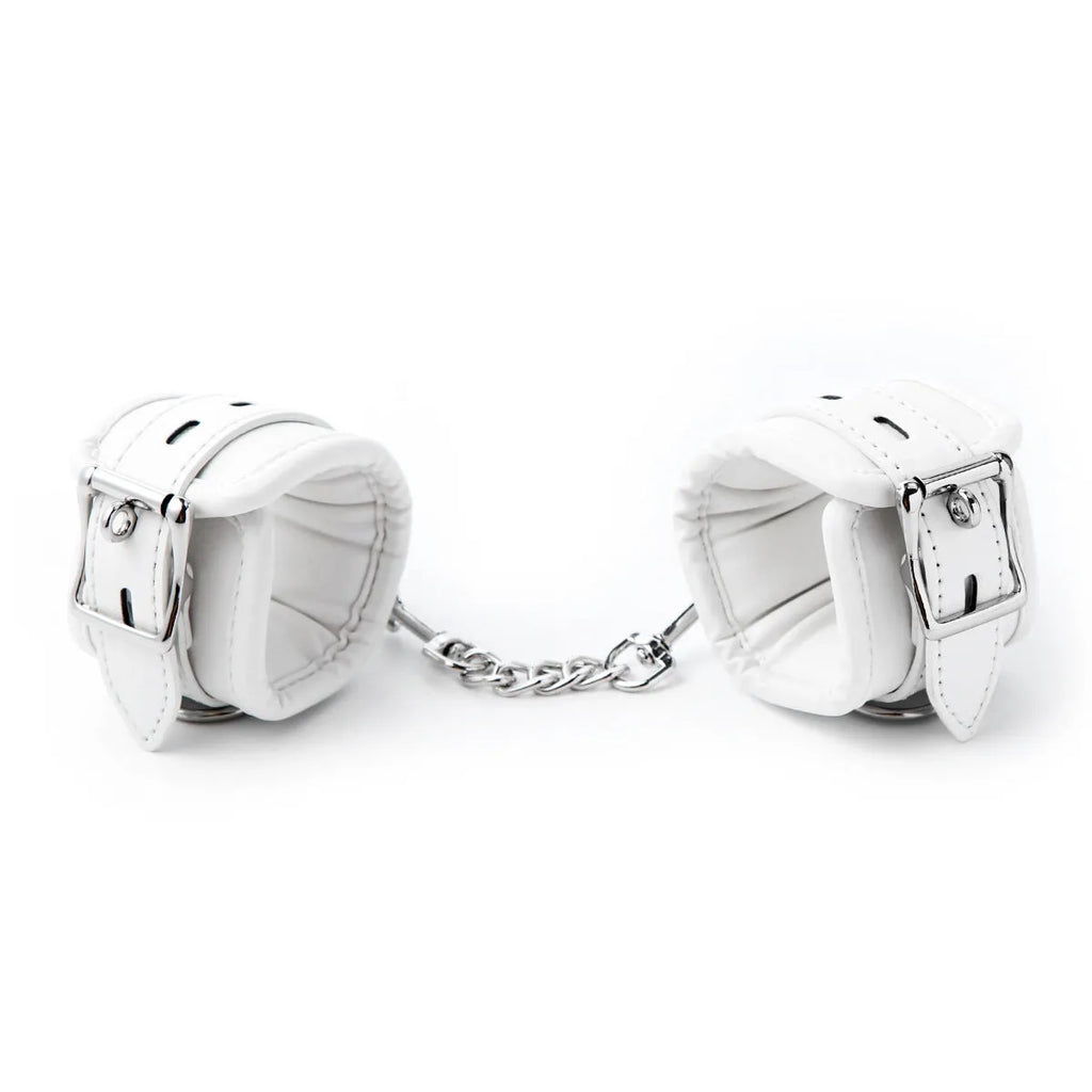 White PU sponge bondage restraint set showing handcuffs, foot cuffs, and a neck cuff on a neutral background.
