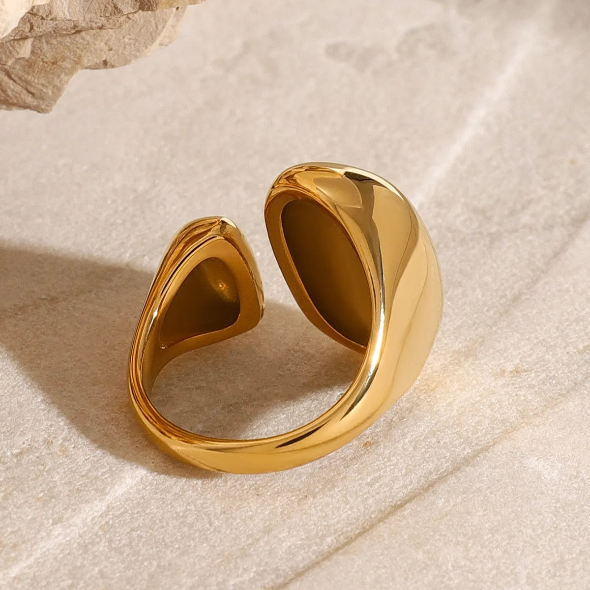 Women's geometric open ring in stainless steel with electroplated finish showing exaggerated angular design