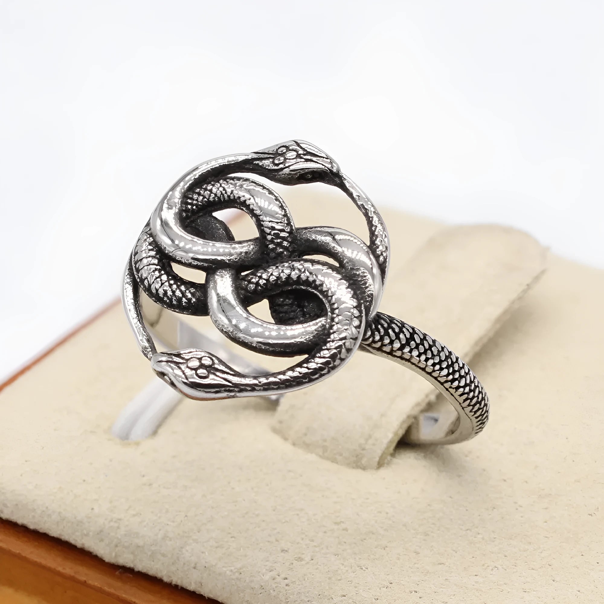 A titanium steel double snake ring in a steel colour retro style, shown on a finger.