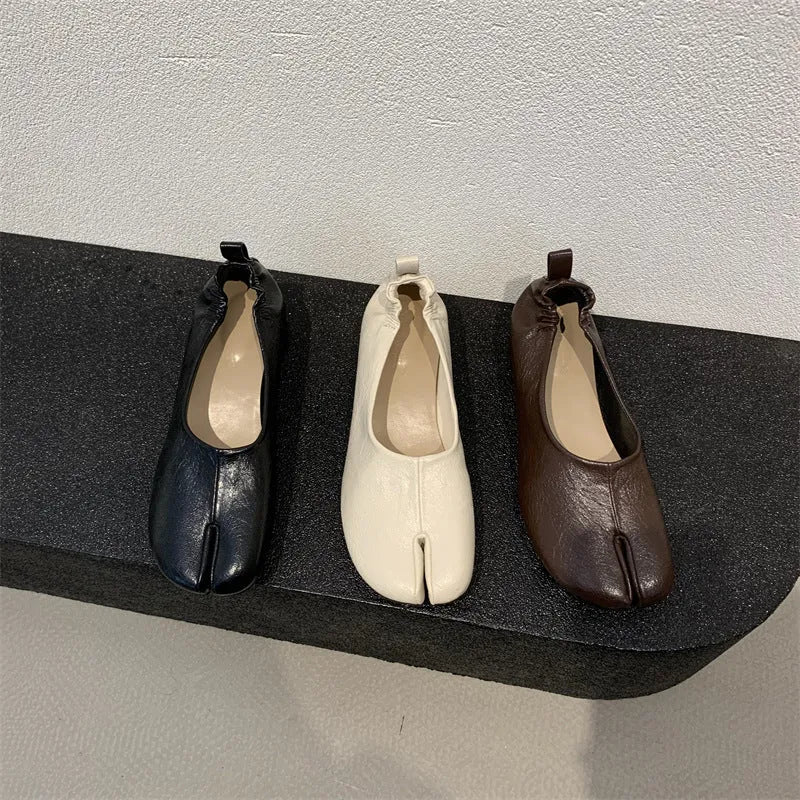 Women's black chunky heel pumps with a horseshoe split toe and round toe design.