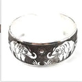 Carved openwork Miao ethnic bracelet in alloy with diamond-cut treatment showing detailed patternwork