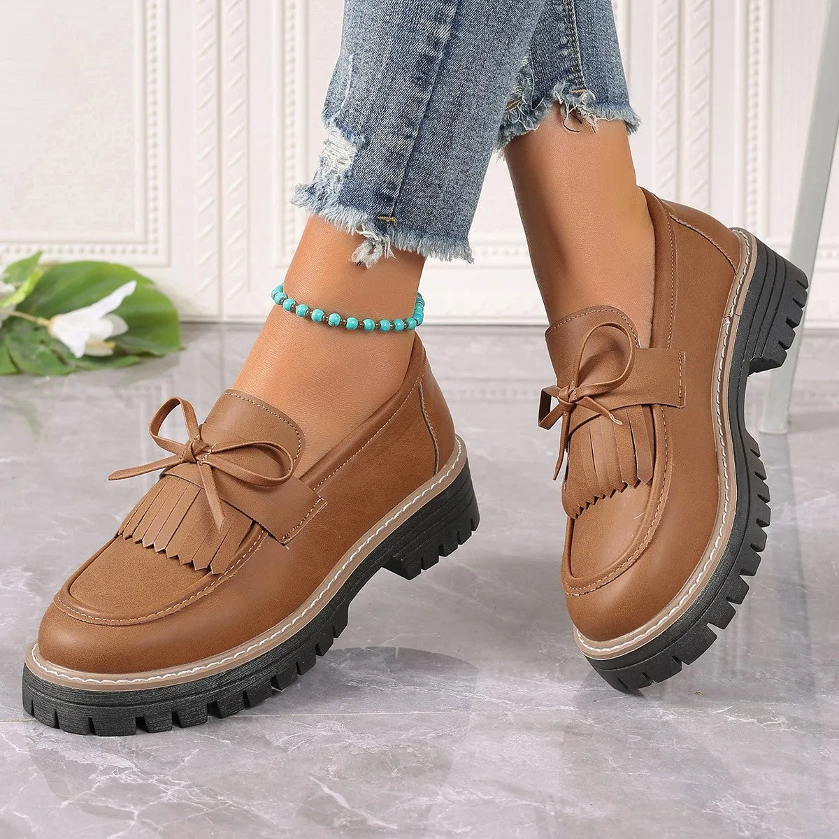 Brown plus size women's loafers with a tassel and bowknot detail on a chunky thick heel.