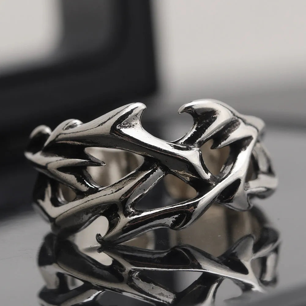 Copper geometric thorn flower ring with adjustable band on a grey background.