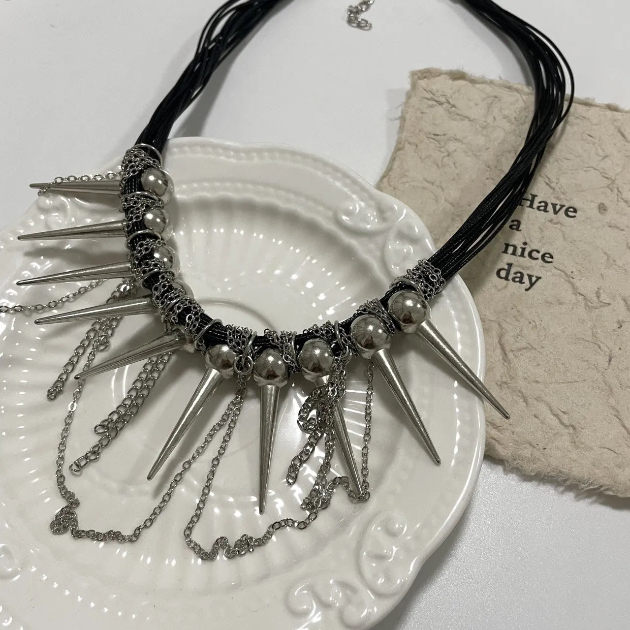 Women's casual leather necklace with electroplated round beads, a winding tassel, and point rivet details.