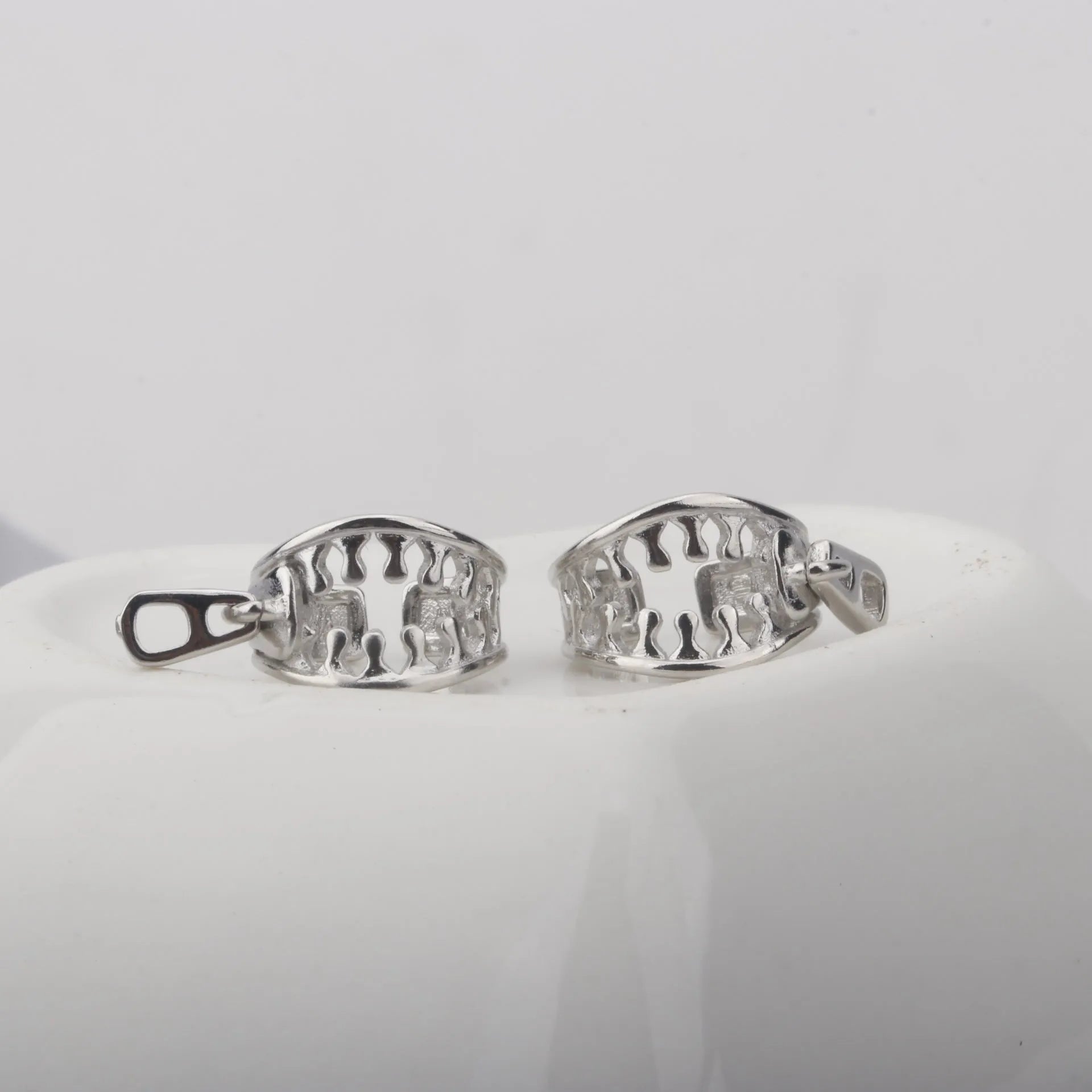 A pair of geometric copper clip-on earrings with a bone clip fastening and linear detail.