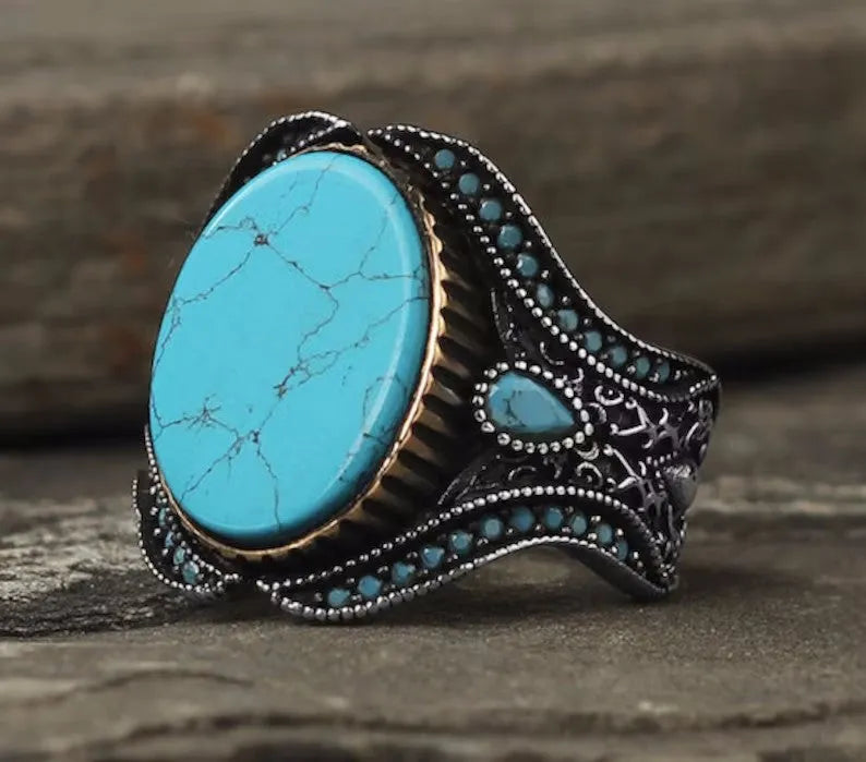 Men's antique silver alloy ring with round band and central turquoise stone on finger