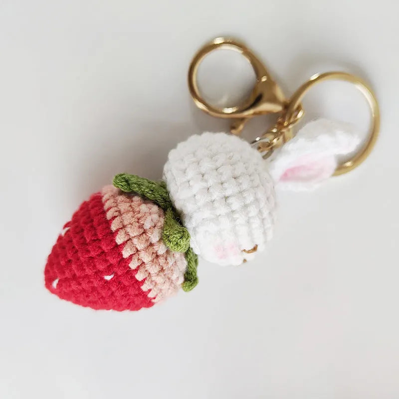 White hand-woven wire rabbit pendant with strawberry pattern attached to a key ring
