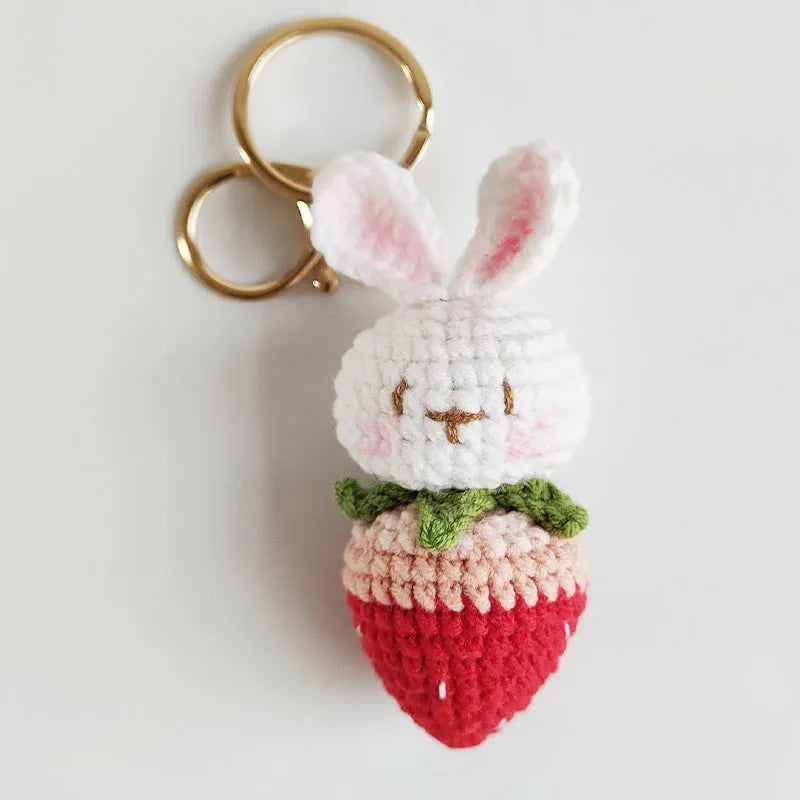 White hand-woven wire rabbit pendant with strawberry pattern attached to a key ring
