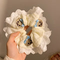 Close-up of a blue cloth hair ring with a cute bear and bow design, showing its large intestine loop style.