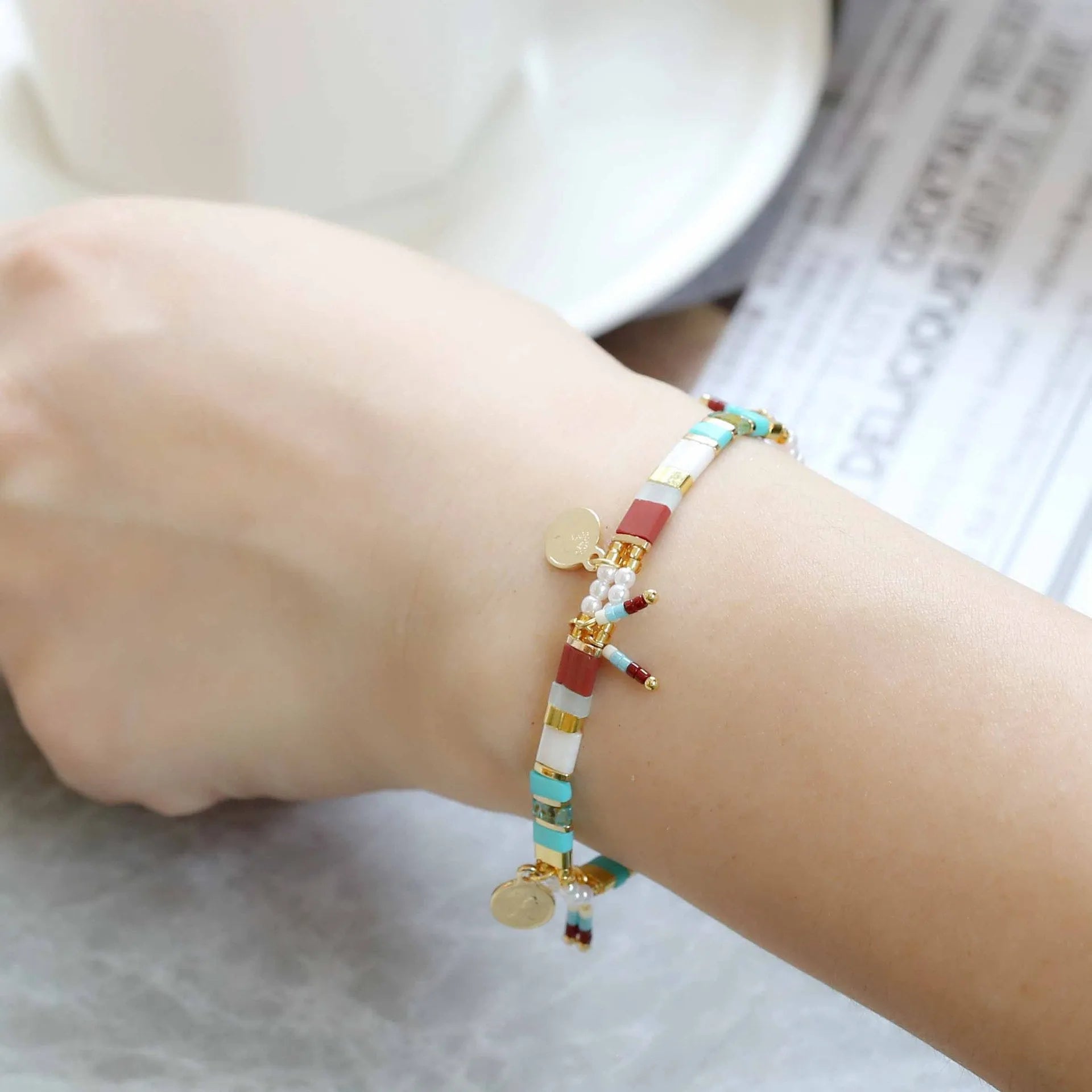Women's imitation pearl beaded bracelet showing six pearl-lift colour variations with manual processing