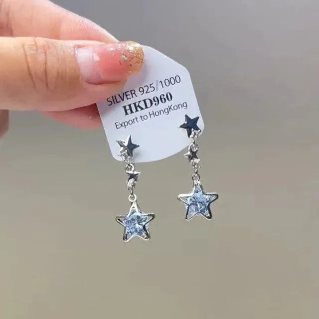Silver-colour geometric heart-shaped clip-on earrings with rhinestones and dangling star tassels.
