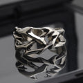 Copper geometric thorn flower ring with adjustable band on a grey background.