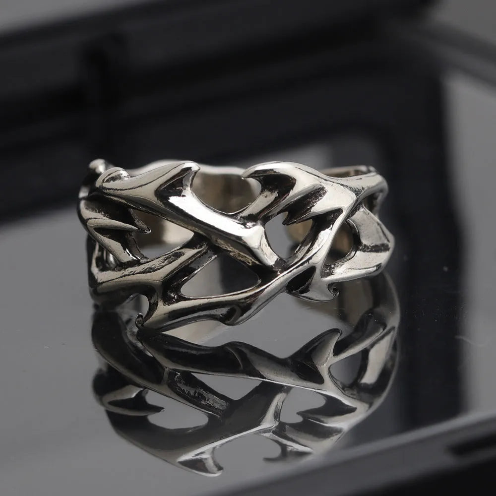 Copper geometric thorn flower ring with adjustable band on a grey background.