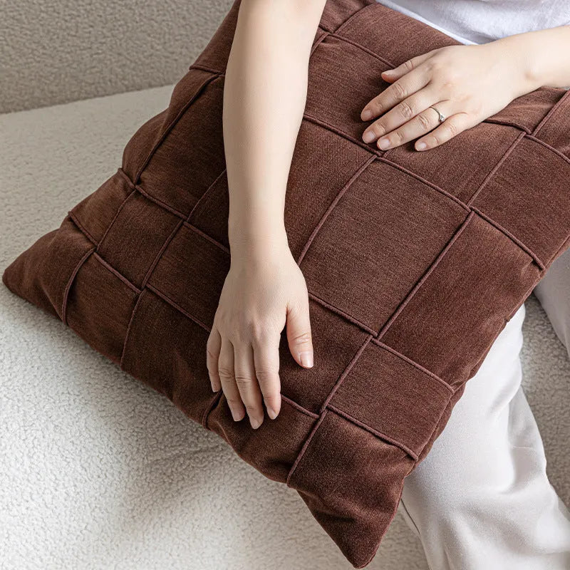 Square 50x50 cm chenille woven pillow cushion in beige colour on a grey sofa.