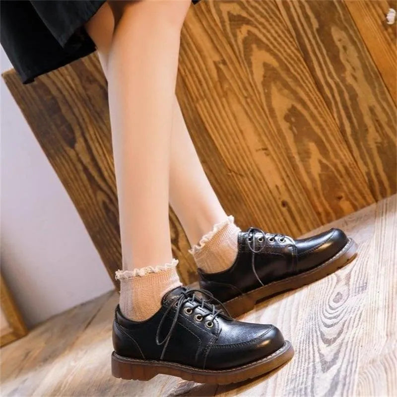 Women's black retro Mary Jane lace-up pumps with round toe and low square heel on a white background.